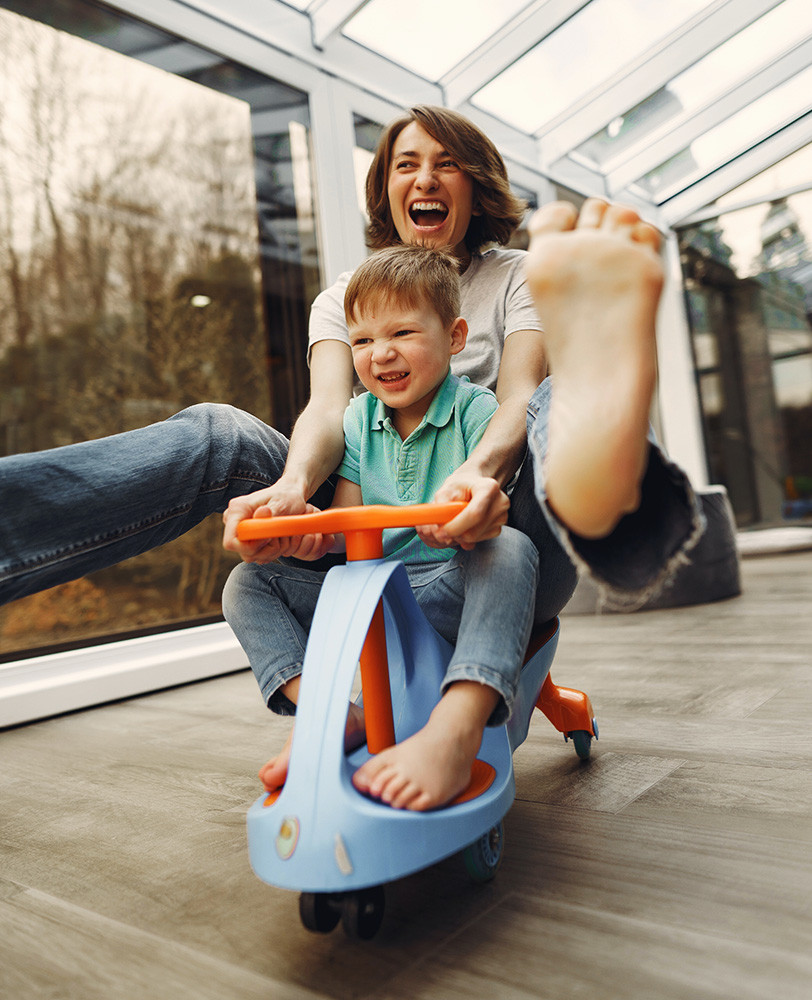 Madre jugando con su hijo en triciclo